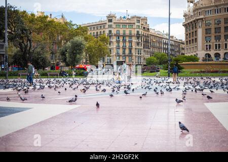 Barcellona, Spagna - 22 settembre 2021: Vista sulla Plaza Catalunya, il cuore di Barcellona. Turismo alimentare i piccioni e scattare foto del bi Foto Stock