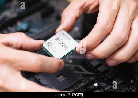 Primo piano dell'ingegnere elettronico che installa il microprocessore Ryzan. Hardware cpu del computer di manutenzione. Chip del processore del computer portatile. Concetto di c Foto Stock