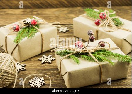 Zero rifiuti di natale concetto. Scatole regalo di natale fatte a mano in carta artigianale con abete rosso branchesand bacche congelate Foto Stock