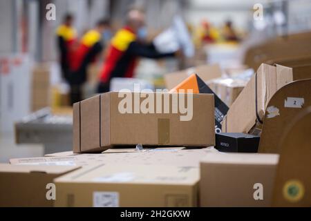 Colonia, Germania. 12 ottobre 2021. Il personale addetto alla consegna dei pacchi smistano e mette i pacchi in un veicolo di consegna presso una base di consegna DHL Deutsche Post. Credit: Rolf Vennenbernd/dpa/Alamy Live News Foto Stock