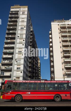 Colpo verticale di un autobus rosso di fronte a due grattacieli in Plaza Italia, quartiere di Palermo, Buenos Aires, Argentina Foto Stock