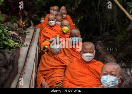 Bangkok, Tailandia. 22 ottobre 2021. I monaci buddisti thailandesi indossano maschere per il viso viste durante la fine della cerimonia della Quaresima buddista al Wat Saket. Il giorno della Quaresima buddista è un giorno di significato religioso per i devoti buddisti e segna l'inizio del periodo di tre mesi, In cui tutti i monaci dovrebbero rimanere nei loro templi e non viaggiare da nessuna parte, il giorno della Quaresima buddista in Thailandia ha iniziato il 25 luglio 2021 e termina il 21 ottobre 2021, quando i devoti buddisti si uniscono al merito per celebrare il ritorno del Signore Buddha sulla terra. Credit: SOPA Images Limited/Alamy Live News Foto Stock