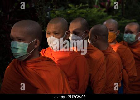 Bangkok, Tailandia. 22 ottobre 2021. I monaci buddisti thailandesi indossano maschere per il viso viste durante la fine della cerimonia della Quaresima buddista al Wat Saket. Il giorno della Quaresima buddista è un giorno di significato religioso per i devoti buddisti e segna l'inizio del periodo di tre mesi, In cui tutti i monaci dovrebbero rimanere nei loro templi e non viaggiare da nessuna parte, il giorno della Quaresima buddista in Thailandia ha iniziato il 25 luglio 2021 e termina il 21 ottobre 2021, quando i devoti buddisti si uniscono al merito per celebrare il ritorno del Signore Buddha sulla terra. Credit: SOPA Images Limited/Alamy Live News Foto Stock