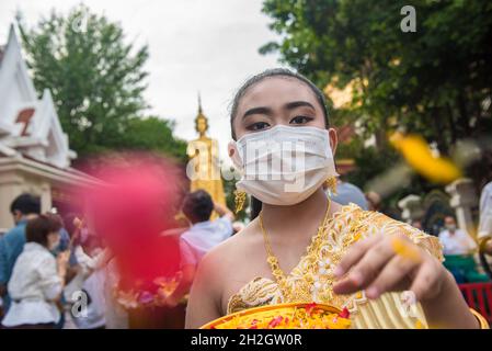 Bangkok, Tailandia. 22 ottobre 2021. Un devoto buddista tailandese vestito con abiti tradizionali irrora fiori durante la fine del giorno della Quaresima buddista. Il giorno della Quaresima buddista è un giorno di significato religioso per i devoti buddisti e segna l'inizio del periodo di tre mesi, In cui tutti i monaci dovrebbero rimanere nei loro templi e non viaggiare da nessuna parte, il giorno della Quaresima buddista in Thailandia ha iniziato il 25 luglio 2021 e termina il 21 ottobre 2021, quando i devoti buddisti si uniscono al merito per celebrare il ritorno del Signore Buddha sulla terra. Credit: SOPA Images Limited/Alamy Live News Foto Stock