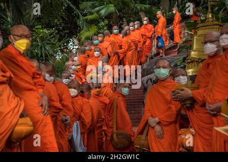 Bangkok, Tailandia. 22 ottobre 2021. I monaci buddisti thailandesi indossano maschere per il viso viste durante la fine della cerimonia della Quaresima buddista al Wat Saket. Il giorno della Quaresima buddista è un giorno di significato religioso per i devoti buddisti e segna l'inizio del periodo di tre mesi, In cui tutti i monaci dovrebbero rimanere nei loro templi e non viaggiare da nessuna parte, il giorno della Quaresima buddista in Thailandia ha iniziato il 25 luglio 2021 e termina il 21 ottobre 2021, quando i devoti buddisti si uniscono al merito per celebrare il ritorno del Signore Buddha sulla terra. Credit: SOPA Images Limited/Alamy Live News Foto Stock