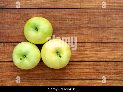 Mele gialle-verdi mature su sfondo di legno Foto Stock