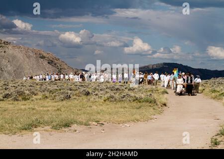 Un gruppo di giovani adolescenti e leader ripromette un'escursione con cart a mano dei pionieri mormoni sulle pianure del Wyoming. Foto Stock