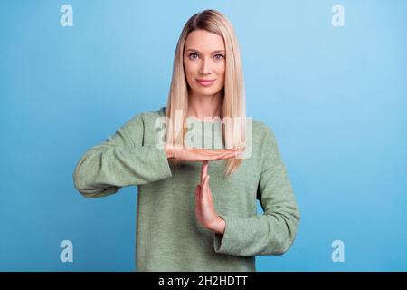 Foto di maturo bella donna mostra mani time-out simbolo arbitro stop isolato su sfondo blu colore Foto Stock