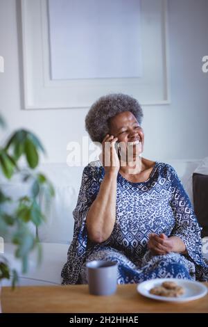 Sorridente anziana afroamericana che parla su smartphone Foto Stock