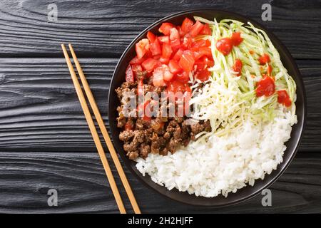 Il Taco Rice Takoraisu è un piatto fusion giapponese messicano che consiste di manzo macinato stagionato, lattuga grattugiata e pomodori tritati serviti su un letto di Foto Stock