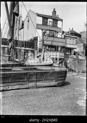 Prospettiva di Whitby, Wapping Wall, Wapping, Tower Hamlets, Greater London Authority, anni '30. L'elevazione del fiume del Prospect of Whitby pub visto da sud sulla riva del fiume a Wapping, mostrando gli uomini sui suoi balconi con vista sul fiume e chiatte in primo piano. Il Prospect of Whitby Public House risale al 1520 circa ed è il pub più antico di Londra lungo il fiume. Foto Stock