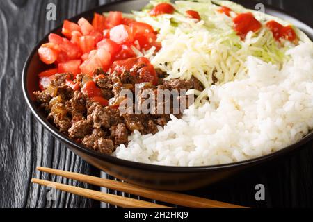 Il Taco Rice Takoraisu è un piatto fusion giapponese messicano che consiste di manzo macinato stagionato, lattuga grattugiata e pomodori tritati serviti su un letto di Foto Stock