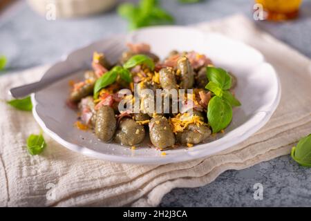 Gnocchi di spinaci fatti in casa con prosciutto e formaggio cheddar Foto Stock