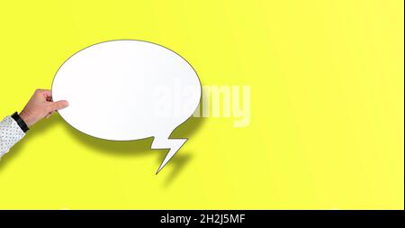 mano che tiene vuoto il fumetto su sfondo giallo con spazio di copia Foto Stock