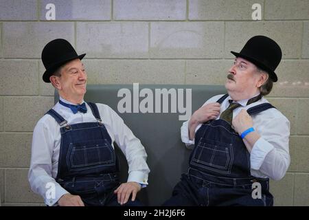 Excel, Londra, Regno Unito. 22 ottobre 2021. Laurel e Hardy si riposano su una panchina. I cosplayer, i fan e i visitatori scendono ancora una volta nel centro espositivo Excel London per MCM Comic con. MCM London Comic con torna il 22-24 ottobre per una celebrazione della cultura pop. Credit: Imagplotter/Alamy Live News Foto Stock