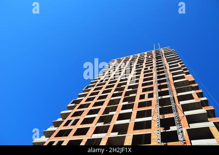 Lavori di costruzione contro il cielo blues. Vista posteriore. Copiare lo spazio per aggiungere elenchi, note, testo, disegni personalizzati. Foto Stock