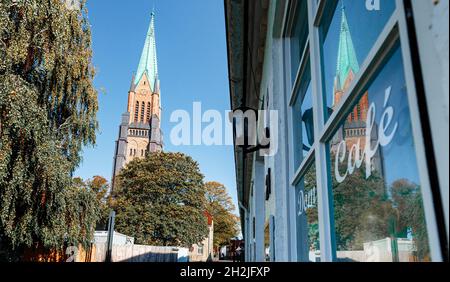 Schleswig, Germania. 22 ottobre 2021. Cattedrale di Schleswig riflessa in una finestra della città vecchia. La riapertura della Cattedrale di San Pietro dello Schleswig dopo quasi quattro anni di ristrutturazione sarà celebrata il 24 ottobre 2021 con un servizio festivo, una reception e un concerto. Per la prima volta, le campane della cattedrale suoneranno di nuovo e il grande organo risuonerà. Credit: Markus Scholz/dpa/Alamy Live News Foto Stock