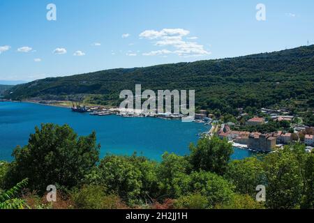 La piccola città di Bakar nella contea di Primorje-Gorski Kotar nella Croazia occidentale, con un terminal merci sulla sinistra Foto Stock