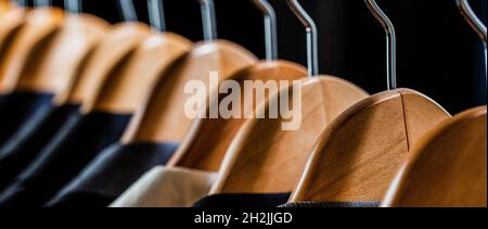 Camicie da uomo, vestito appeso al rack. Abiti da uomo in diversi colori appesi su un appendiabiti in un negozio di abbigliamento al dettaglio, primo piano Foto Stock