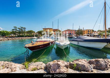 Porto del piccolo borgo di Cisano con molte barche ormeggiate, località turistica sulla costa del Lago di Garda. Comune di Bardolino, provincia di Verona, Italia. Foto Stock