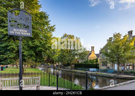 Segno del villaggio di Bourton-on-the-Water, una popolare destinazione Cotswold con il fiume che scorre dolcemente Windrush che attraversa il centro del villaggio. Foto Stock