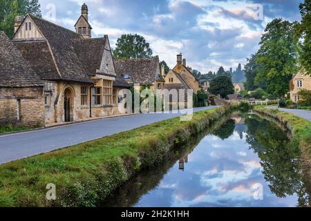 Cottage calcarei accanto al River Eye nel pittoresco villaggio di Cotswold di macellazione inferiore in Gloucestershire, Inghilterra. Foto Stock