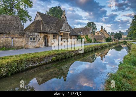 Cottage calcarei accanto al River Eye nel pittoresco villaggio di Cotswold di macellazione inferiore in Gloucestershire, Inghilterra. Foto Stock