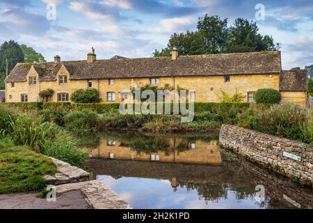 Cottage calcarei accanto al River Eye nel pittoresco villaggio di Cotswold di macellazione inferiore in Gloucestershire, Inghilterra. Foto Stock