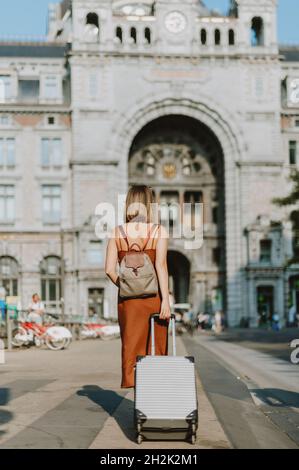 Donna turistica che cammina fuori dalla stazione ferroviaria di Anversa Foto Stock