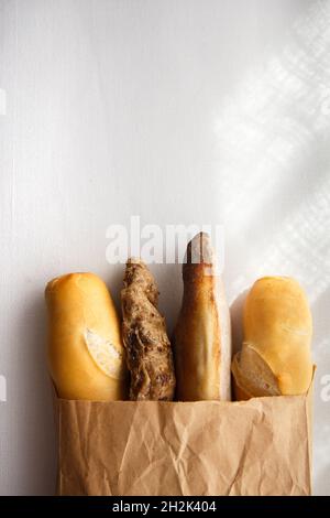 segale, grano, baguette multigrain in un sacchetto di carta su sfondo bianco Foto Stock