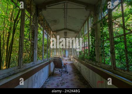 Sedia a rotelle nel corridoio di un sanatorio abbandonato Foto Stock