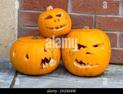scolpito tre zucche di halloween, decorazione e concetto di vacanza, zucche intagliate per una festa di divertimento, facce divertenti e arrabbiate, lanterna di jack o, halloween t Foto Stock