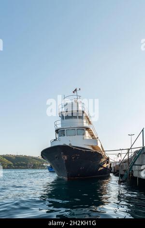 Barca da pesca ormeggiata ad un molo di cemento sulla costa del canale del Bosforo Foto Stock