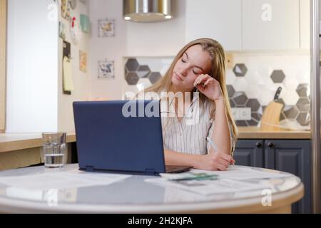 Donna d'affari affaticata togliendo gli occhiali stanchi del lavoro del calcolatore, impiegato esausto che soffre dai sintomi di visione blurry dopo l'uso lungo del laptop, sopra Foto Stock