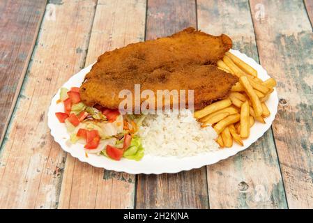 Piatto combo colombiano, cotoletta di valluna con milanesa di vitello, patatine fritte, riso bianco cotto e insalata di pomodoro e lattuga Foto Stock