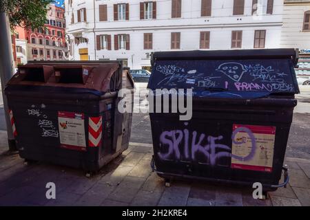 Roma, Italia spazzatura bidoni vicino ad una strada. Grandi spazzatrici utilizzate per lo smaltimento dei rifiuti ai margini del marciapiede nella capitale romana. Foto Stock