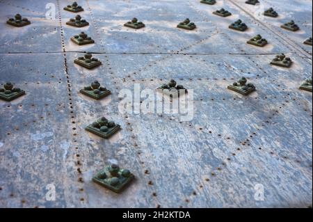 particolare di alcuni prigionieri o rivetti su una vecchia porta della chiesa Foto Stock