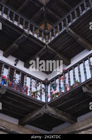 Particolare di balconi in legno con fiori in una piazza castigliana Foto Stock