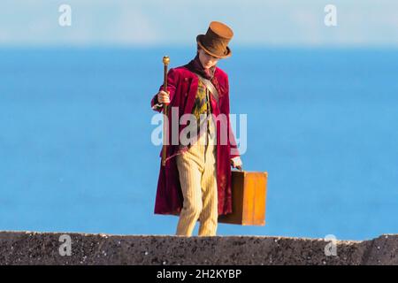 Scene per il nuovo film Wonka con Timothée Chalamet in fase di ripresa sul porto di Cobb a Lyme Regis in Dorset l'11 ottobre 2021. Immagine Credi Foto Stock