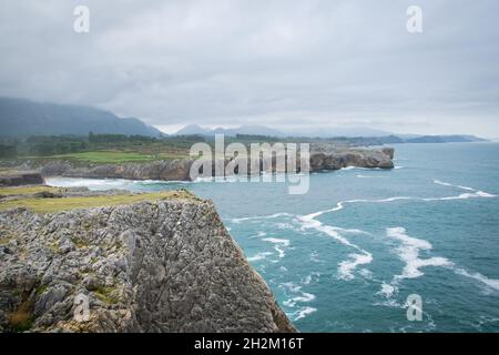 Scogliere drammatiche sulla costa cantabriana nel famoso Bufones de Pia in una giornata d'autunno nebbiosa. Moody paesaggio costiero nelle Asturie, Spagna settentrionale. Foto Stock