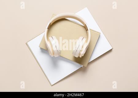Cuffie e libri moderni su sfondo a colori Foto Stock