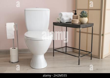 Bagno moderno con porta carta igienica e tavolo con accessori Foto Stock