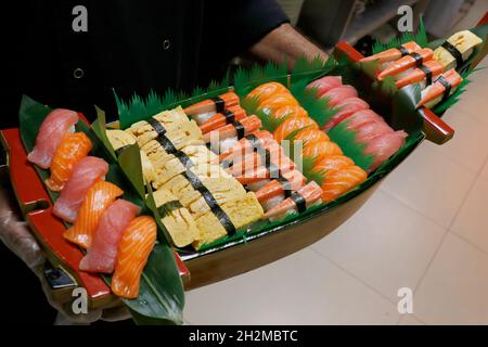 una selezione multipla di sushi panini giapponesi in una barca, include salmone, tonno, granchio, gamberetti ecc. Foto Stock