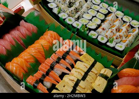 una selezione multipla di sushi panini giapponesi in una barca, include salmone, tonno, granchio, gamberetti ecc. Foto Stock