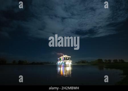 Papenburg, Germania. 23 ottobre 2021. La nave da crociera di 337 metri 'Aidacosma' sarà trasferita attraverso l'EMS al Mare del Nord durante la notte. Il colosso da crociera di nuova costruzione 'Aidacosmaa' ha iniziato il suo rimorchiatore dal cantiere Meyer sull'EMS al Mare del Nord. Credit: Mohssen Assanimoghaddam/dpa/Alamy Live News Foto Stock