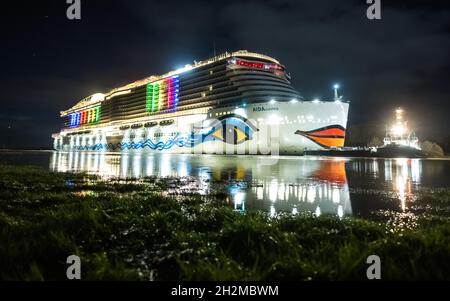 Papenburg, Germania. 23 ottobre 2021. La nave da crociera di 337 metri 'Aidacosma' sarà trasferita attraverso l'EMS al Mare del Nord durante la notte. Il colosso da crociera di nuova costruzione 'Aidacosmaa' ha iniziato il suo rimorchiatore dal cantiere Meyer sull'EMS al Mare del Nord. Credit: Mohssen Assanimoghaddam/dpa/Alamy Live News Foto Stock