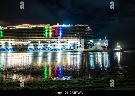 Papenburg, Germania. 23 ottobre 2021. La nave da crociera di 337 metri 'Aidacosma' sarà trasferita attraverso l'EMS al Mare del Nord durante la notte. Il colosso da crociera di nuova costruzione 'Aidacosmaa' ha iniziato il suo rimorchiatore dal cantiere Meyer sull'EMS al Mare del Nord. Credit: Mohssen Assanimoghaddam/dpa/Alamy Live News Foto Stock