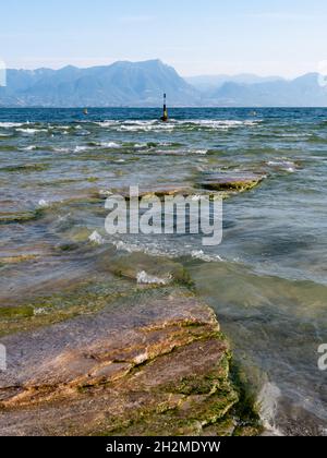 Spiaggia della Giamaica sul Lago di Garda nella Penisola di Sirmione, Italia con Buoy in mattinata estiva Foto Stock