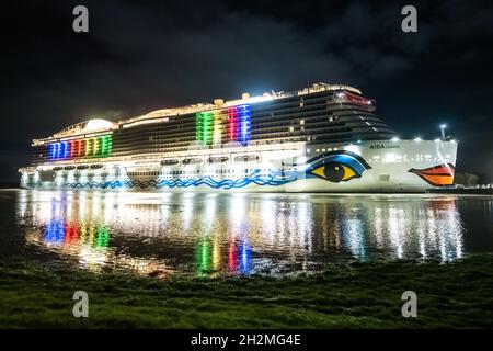 Papenburg, Germania. 23 ottobre 2021. La nave da crociera di 337 metri 'Aidacosma' sarà trasferita attraverso l'EMS al Mare del Nord durante la notte. Il colosso da crociera di nuova costruzione 'Aidacosmaa' ha iniziato il suo rimorchiatore dal cantiere Meyer sull'EMS al Mare del Nord. Credit: Mohssen Assanimoghaddam/dpa/Alamy Live News Foto Stock