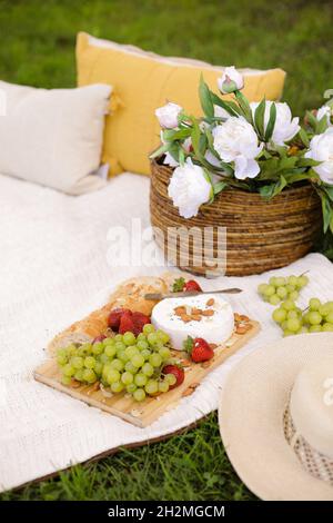 Cesto per pic-nic con prodotti alimentari sul verde prato soleggiato. Foto Stock
